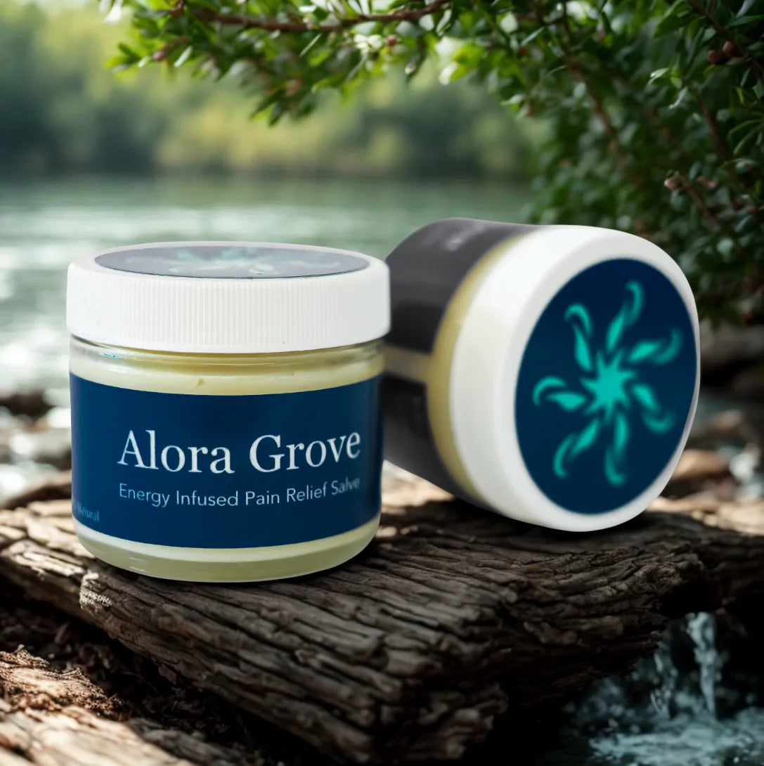 Two jars of Alora Grove pain relief salve on a wooden log by the water
