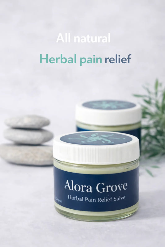 Alora Grove™ herbal pain relief salve jar with 'All natural Herbal pain relief' text, stones and green leaves